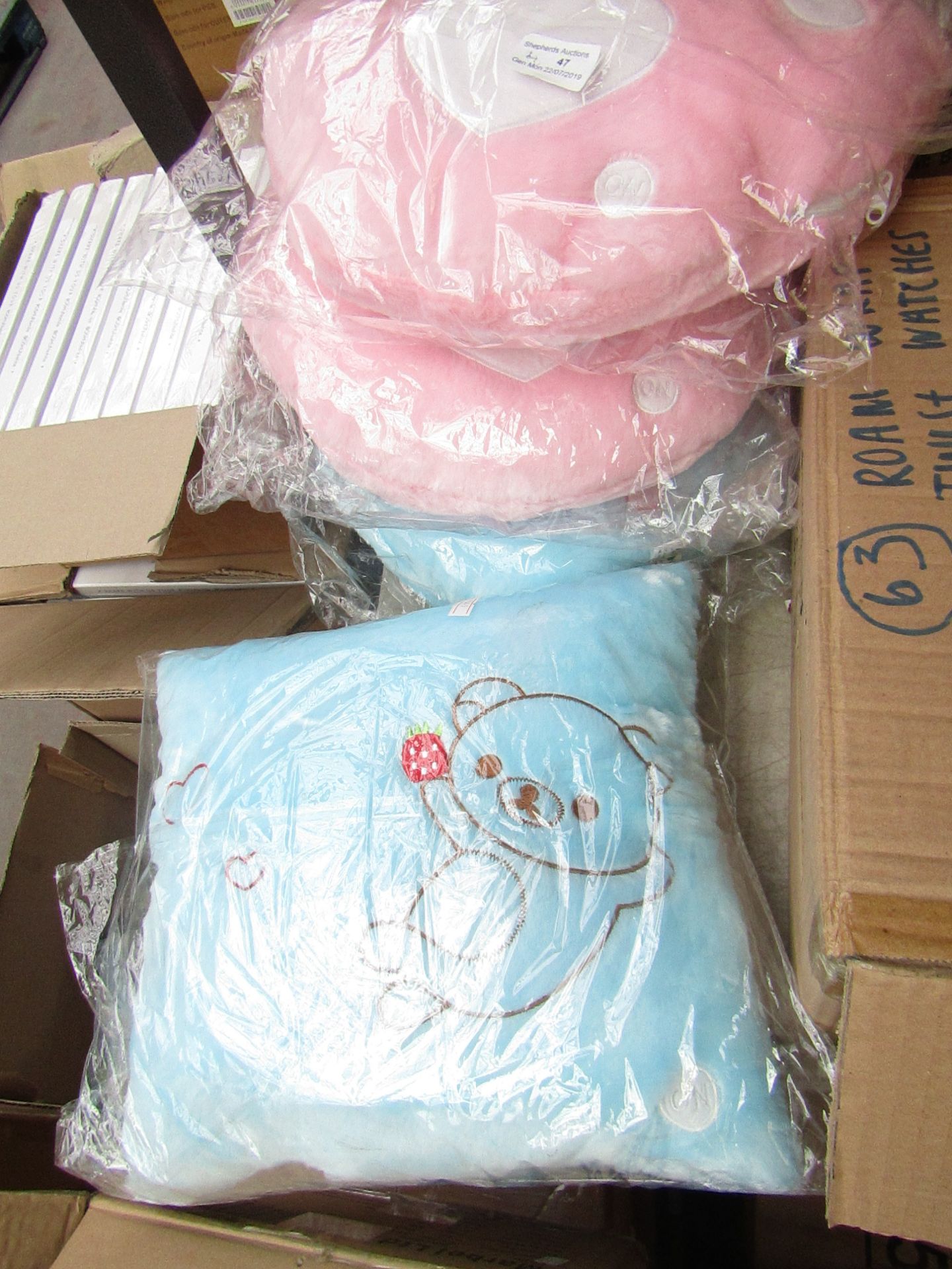 2 x pink bear paw cushions and 2 x blue tedy bear cushions, packaged