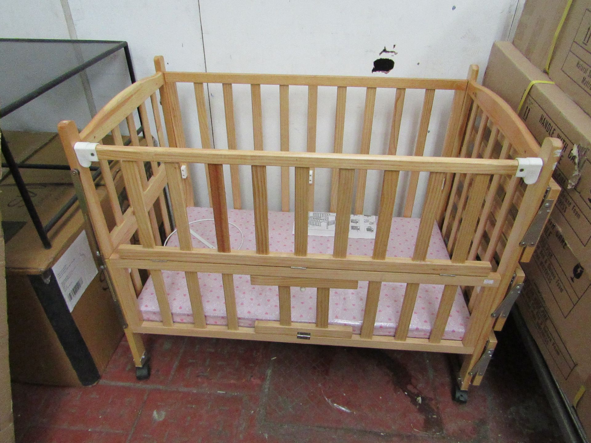 Childs cott with side shelves and Pink mattress, new and boxed.