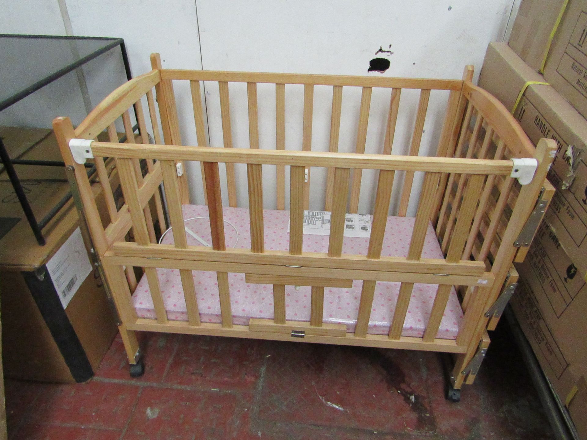 Childs cott with side shelves and Pink mattress, new and boxed.