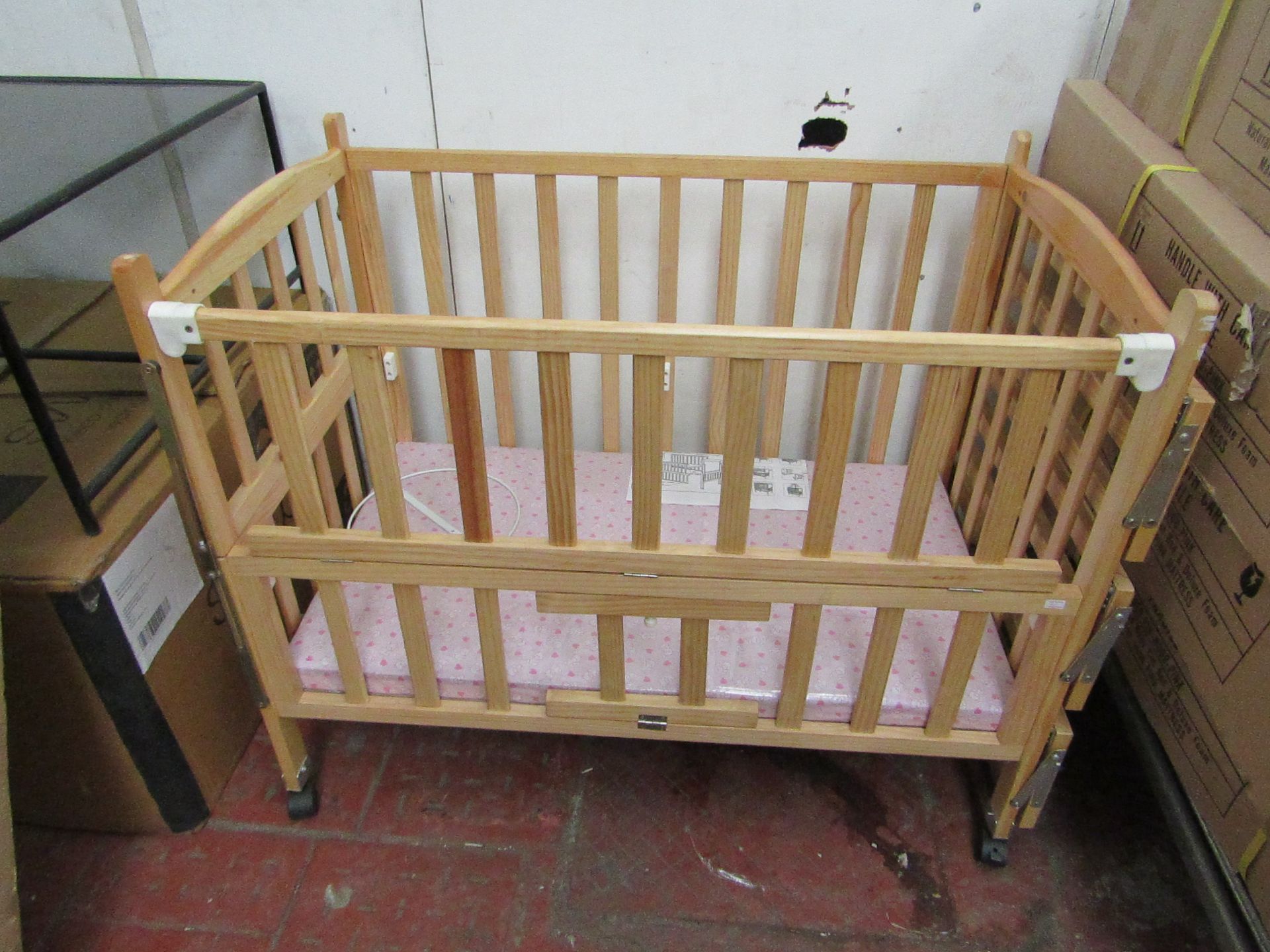 Childs cott with side shelves and Pink mattress, new and boxed.