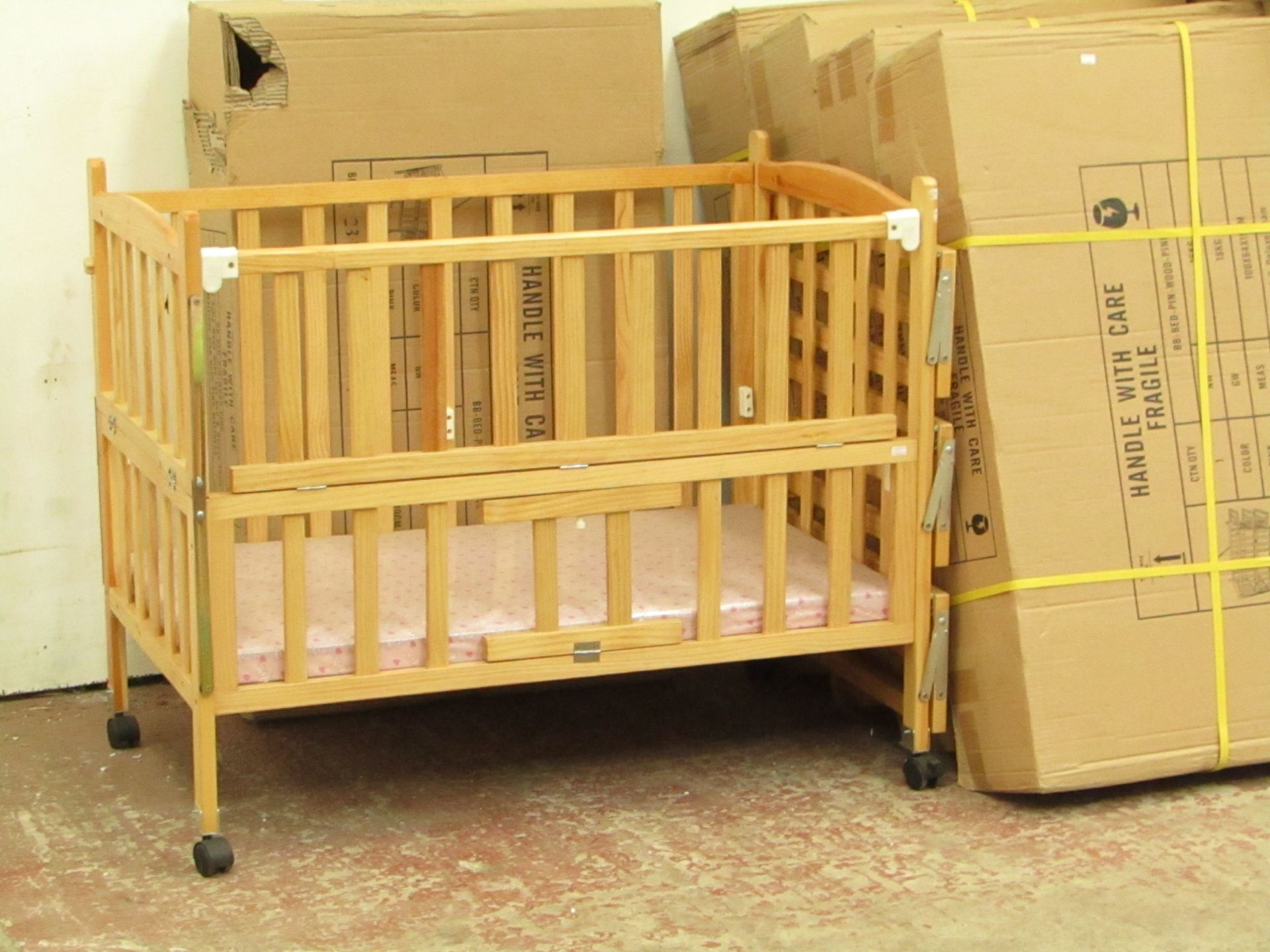 Childs cott with side shelves and Pink mattress, new and boxed.