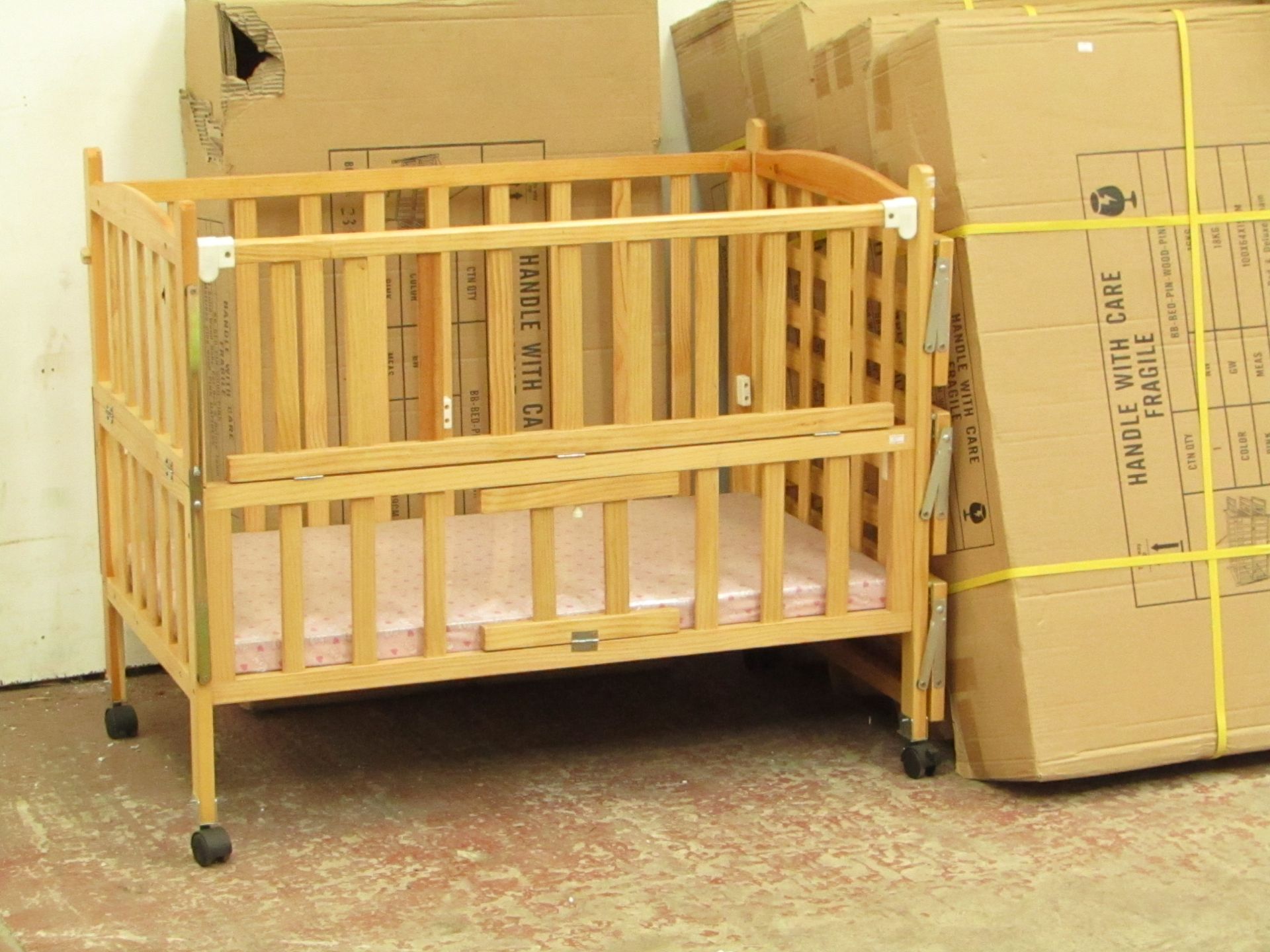 Childs cott with side shelves and Pink mattress, new and boxed.