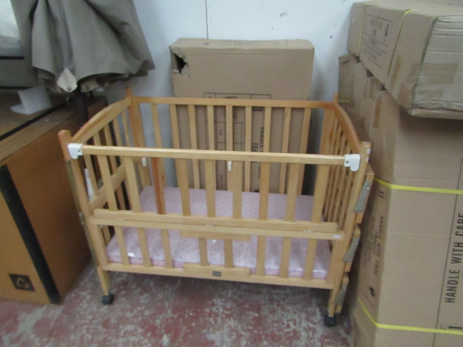 Childs cott with side shelves and Pink mattress, new and boxed.