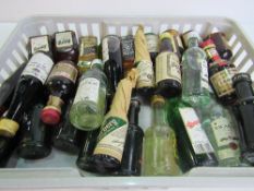 Tray of assorted miniature spirits bottles with contents. Estimate £10-20.