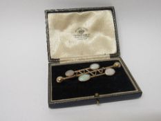 Tested 14ct gold stylized opal bar brooch, wt 10.5gms. Estimate £180-200.