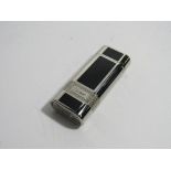 Silver plated & black enamel flip top roller lighter, marked with Cartier panels each side, code