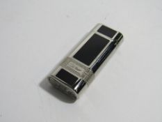 Silver plated & black enamel flip top roller lighter, marked with Cartier panels each side, code