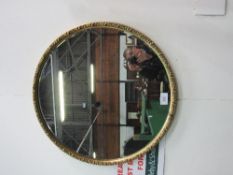 Large circular decorated gilt framed bevel-edged wall mirror, 80cms diameter. Estimate £20-40.