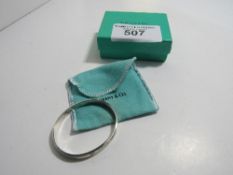 Tiffany & Co bangle marked T & Co 1837 with pouch, box and carrier bag. Estimate £50-60