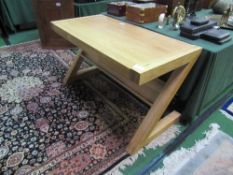 Laminated oak Z-frame desk with frieze drawer, 135cms x 65cms x 76cms. Estimate £100-120.