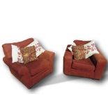 Pair of rust coloured easy chairs & cushions. Estimate £50-60.