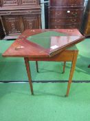 Mahogany swivel 'envelope' top card table on tapered legs to castors. Estimate £100-120.