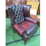 Winged Chesterfield-style button-back Ox blood leather armchair. Estimate £50-70.