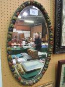 Oval bevel-edged mirror with painted fruit frame, height - 85cms & a gilt framed bevel-edge wall