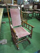 Turned wood framed American style rocking chair. Estimate £30-50.