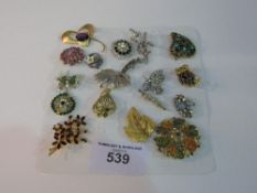 18 various costume jewellery brooches. Estimate £10-20.