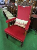 Oak framed upholstered open armchair on castors.