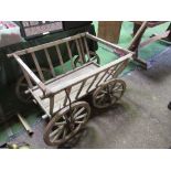 Small 4 wheel hand cart on metal tyred spoked wheels with railed sides. Estimate £50-80.