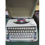 Vintage Olympia Splendid 66 cream coloured portable typewriter with cover. Estimate £10-20.