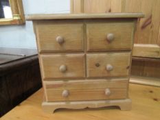 Miniature chest of 2 over 1 drawers. Estimate £20-30.