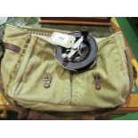 A vintage Bakelite Australian centre pin fishing reel & a canvas game bag. Estimate £20-30.