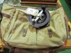 A vintage Bakelite Australian centre pin fishing reel & a canvas game bag. Estimate £20-30.