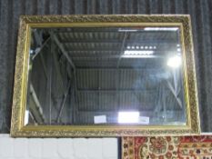 Rectangular decorative gilt framed bevel-edged mirror by Morris Mirrors, 72cms x 100cms. Estimate £