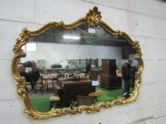 Ornate, carved gilt framed decorative wall mirror, 120cms x 90cms. Estimate £40-60.