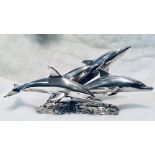 A sterling silver sculpture of leaping dolphins, designed by M King & cast by Roger Squires.