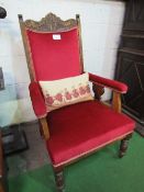 Oak framed upholstered open armchair on castors.