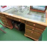 Pine pedestal desk with green leather skiver, on castors, 154cms x 76cms x 76cms. Estimate £50-70.