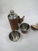 Small flask in a leather holder & 4 cups in leather container. Estimate £15-25.