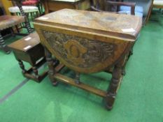 Small oak drop-side table with heavily carved top, turned & carved legs, 106cms (open) x 71cms.