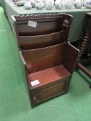 Small oak magazine rack with cupboard to base. Estimate £30-50.