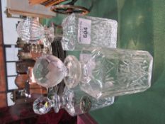 3 cut glass decanters, 1 with a silver label. Estimate £50-60.