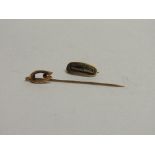 9ct gold stick pin with horseshoe shape top with red stone & a gold coloured mourning brooch.