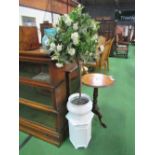 White ceramic jardinière on stand c/w artificial rose bush. Estimate £20-30.