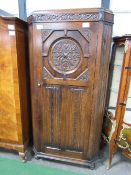 1920's oak hall cabinet with canted reeded sides, carved medallion above linen fold carving to door,