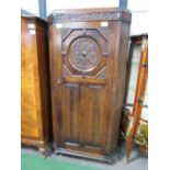 1920's oak hall cabinet with canted reeded sides, carved medallion above linen fold carving to door,