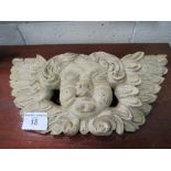 Carved wooden wall plaque of a putto. Estimate £30-50.