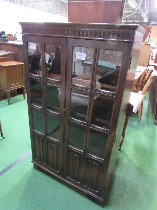 1930's style oak bookcase with glazed doors & linen fold panels, 79cms x 35cms x 136cms. Estimate £