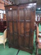 Dark oak double wardrobe with carved panel doors, 107cms x 56cms x 180cms. Estimate £60-80.