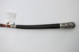 An interesting and rare whip with a finely plaited leather handle, ornate ferrule and butt cap.