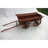 Wooden model of a four wheel farm wagon with brass fittings. Length 32ins