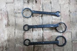 Three black metal carriage spanners