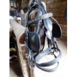 Two black leather driving bridles with whitemetal fittings; no bits