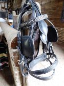 Two black leather driving bridles with whitemetal fittings; no bits