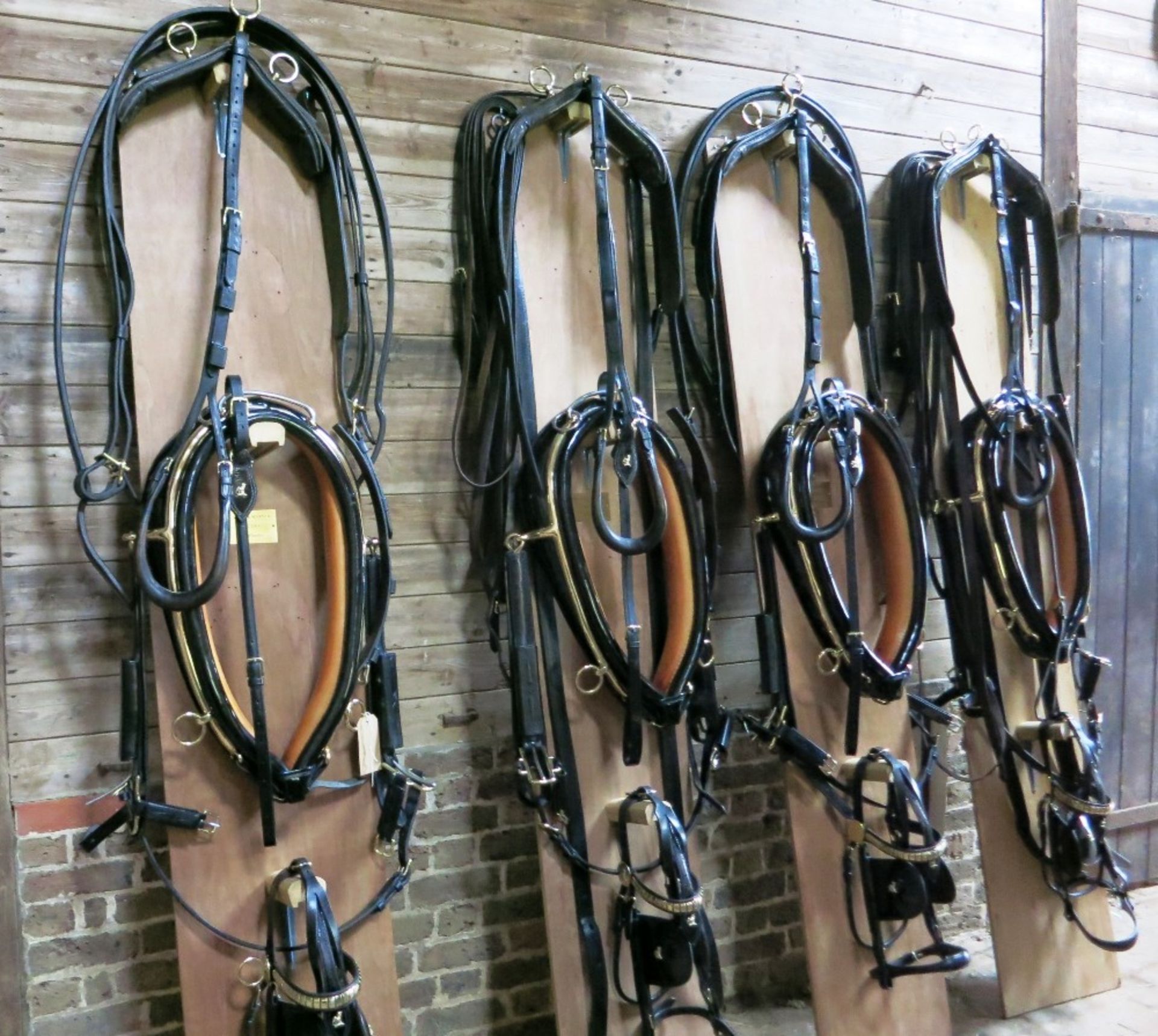 An exceptional complete TEAM set of black/patent leather/brass full size harness, the tan coloured