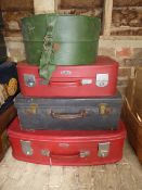 Three various sized suitcases, green hat box and a pair of 1950's Puck Master speed skates, size 8