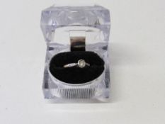 18ct gold lady's solitaire diamond ring with raised platinum shoulders. Estimate £130-150.